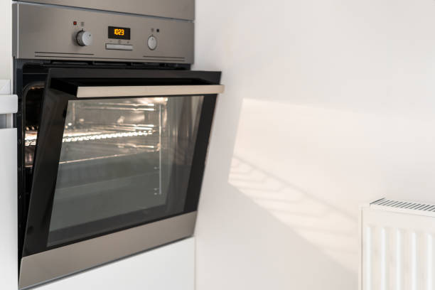 istock Slightly opened steel oven in white kitchen interior 1320642142