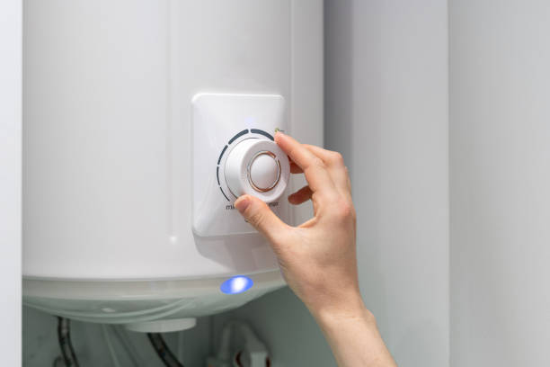 Woman setting temperature program on electric boiler Cropped photo of female adjusting temperature on bathroom electric boiler hanging on wall, using control knob. Water heater in modern apartment knob stock pictures, royalty-free photos & images