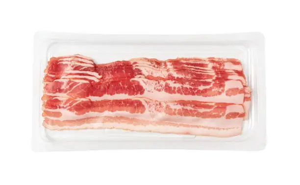 Raw smoked bacon in plastic pack isolated. Streaky brisket slices on tray, fresh thin sliced bacon on white background