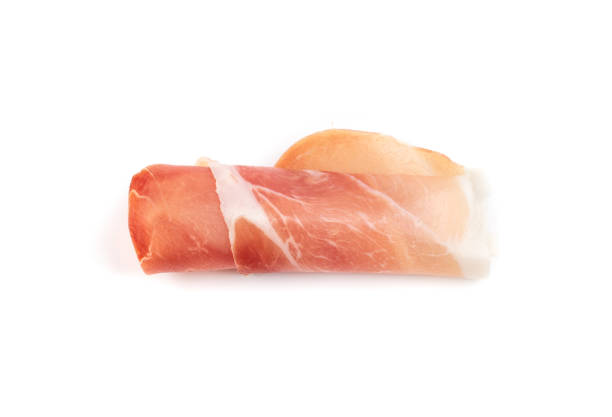 Slices of prosciutto isolated. Spanish jamon cut, parma ham, serrano or iberico on white background closeup