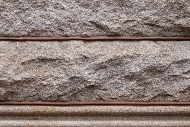 Background of rusticated granite blocks divided by beaded mortar, architectural details, horizontal aspect