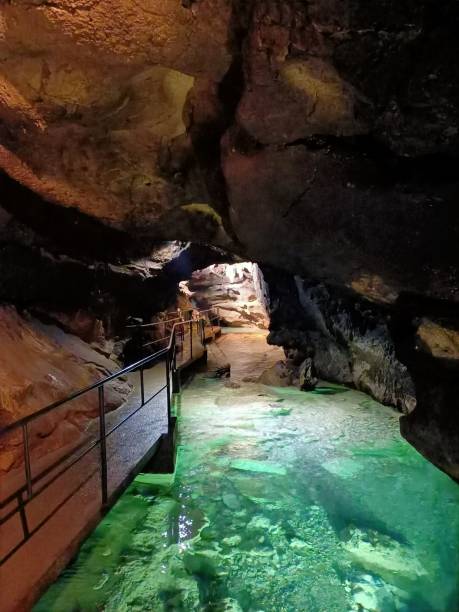 istock Underground mountain cave with river and stalactites and stalagmites 1320648450