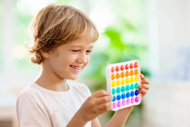 Photo of Kids with pop it sensory toy. Stress relief.