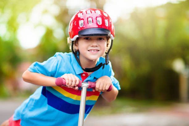 istock Little boy riding scooter. Kids ride kick board. 1320649823