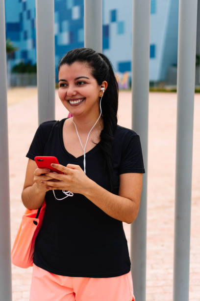 istock Smiling woman sending a message on her cell phone 1320651139