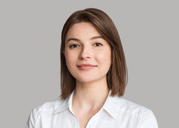 Young woman close-up isolated studio portrait Beautiful caucasian girl looking at camera. Studio shot. Isolated on gray background. Beauty, business, people concept headshot stock pictures, royalty-free photos & images