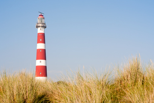 Iconic red and white lighthouse in the dunes of Ameland, the Netherlands