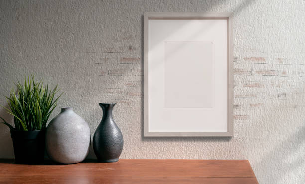 istock Mockup black picture frame on brick wall and ceramic vase on wooden table. 1320657629