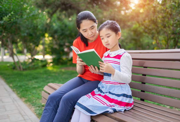 istock Little Girl and Mother Reading Book 1320657713