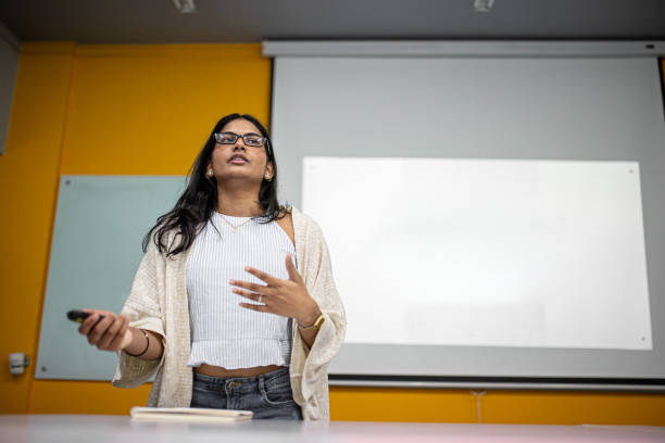 istock Asian college student is making a presentation in front of projector screen 1320658258