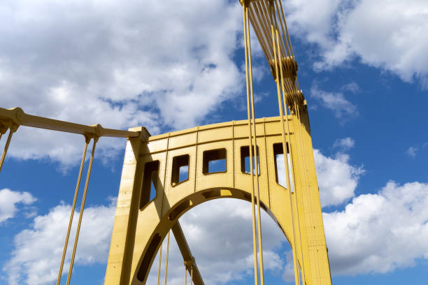 istock Bright yellow metal bridge structure against a blue sky with clouds, bright sunny day 1320659576