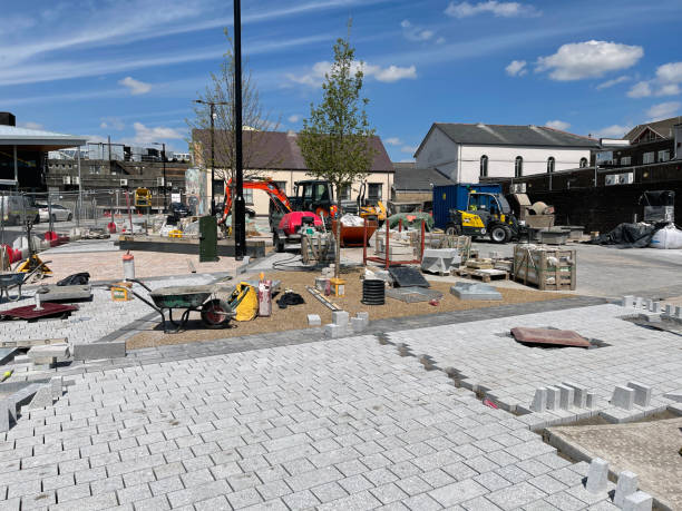 New paving slabs being laid in a town centre Merthyr Tydfil, Wales - May 2021: New block paving being laid outside the new bus station in Merthyr town centre. merthyr tydfil stock pictures, royalty-free photos & images