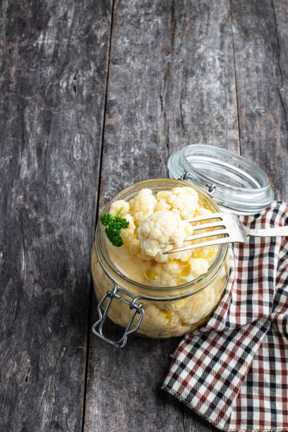 istock Pickled cauliflower in glass jar on rustic wooden table 1320661621