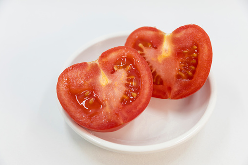 Close-up of Fresh red tomatoes in a white plate on white background