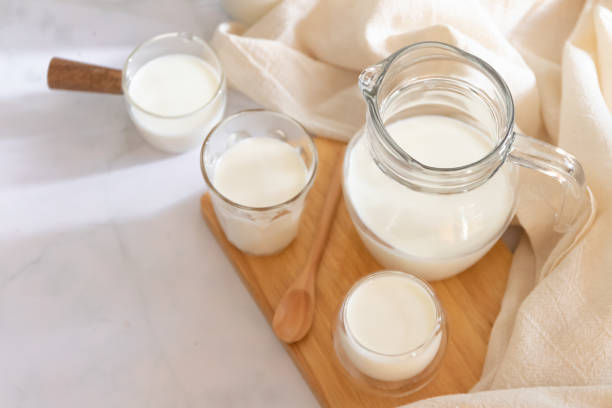 milk drinks in clear jars and glass of milk on wooden board. healthy drink concept. - dairy farm liquid food and drink splashing imagens e fotografias de stock