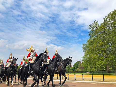 Mounted Coldstream Guards on exercise in Hyde Park, London, England, UK. Bright sunny days in the capital city highlight the classical architecture and iconic sites in these outdoors scenes of London in early summer, England, UK