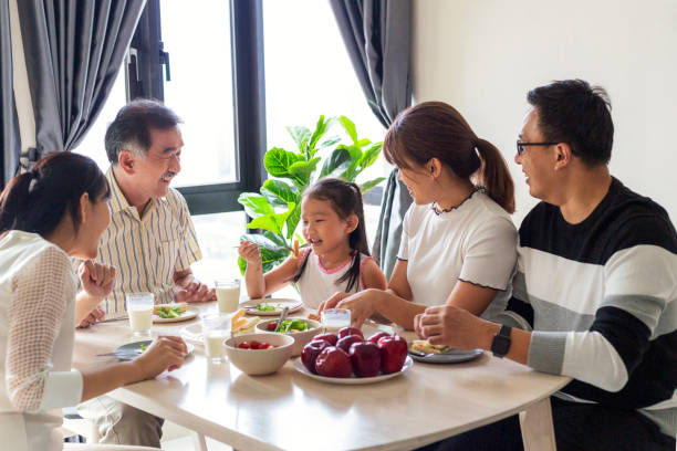 szczęśliwa rodzina rozmawiająca ze śniadaniem w kuchni - apple eating healthy eating friendship zdjęcia i obrazy z banku zdjęć