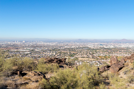 This is the view of the Phoenix, Arizona skyline on a winter day.  This shot was taken from the Mormon Trail located in the South Mountain Park.  The rugged desert terrain is obvious in the foreground with the city in the background.
