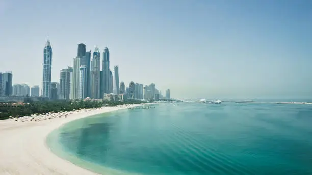 Dubai city skyline with skyscrapers, sea and beach. Travel, tourism, cityscape or business concept. Fastest growing city in the world. United Arab Emirates. High quality image