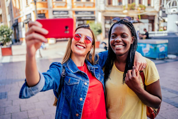 istock Smiling female friends taking selfie 1320682017