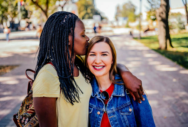 istock Multiethnic girlfriends kissing outdoor 1320684044