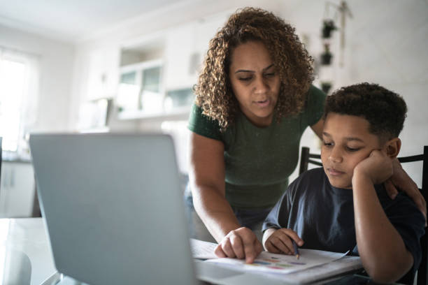istock Mother helping bored son with homework 1320684195