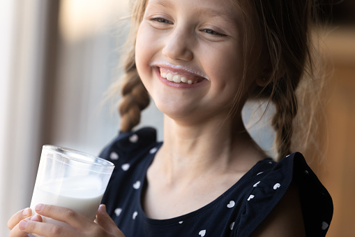Chica feliz con bigote divertido bebiendo leche photo