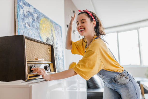 donna che si diverte, canta, balla e ascolta musica a casa - hardware audio foto e immagini stock