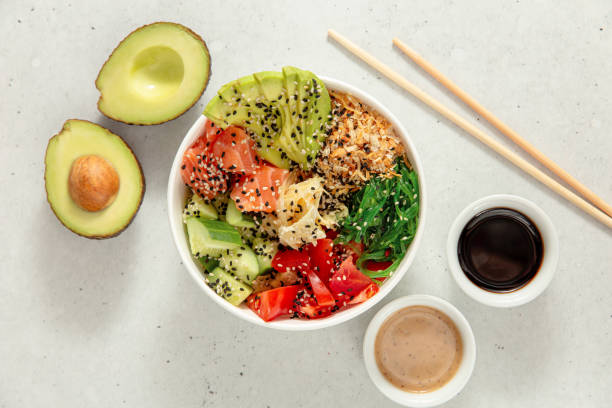 poke bowl con salmón, aguacate, pepino, tomate y algas. vista superior - wakame salad fotografías e imágenes de stock