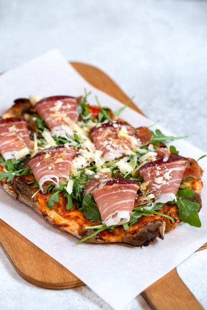 Fresh italian prosciutto pizza on wooden board
