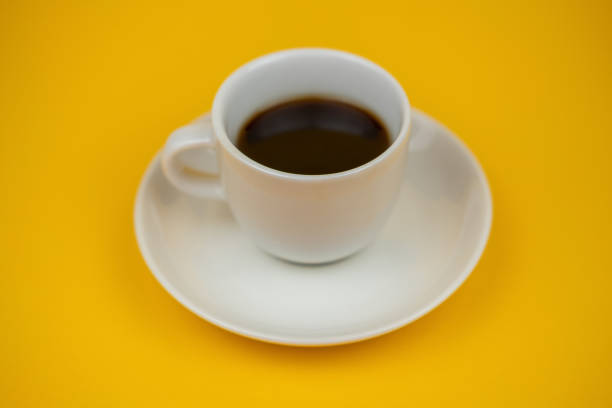 istock A white cup of coffee on a yellow background 1320697224