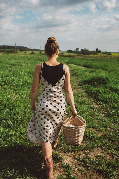 istock Girl with a wicker picnic basket in her hands. 1320697962