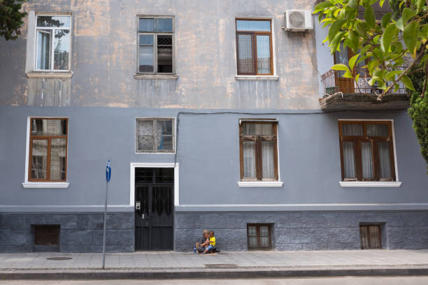 batumi, georgia - 06 de agosto de 2018: personas sin hogar sentadas afuera, en la ciudad. el pueblo no ha sido identificado - brick wall homelessness wall begging fotografías e imágenes de stock