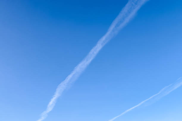 istock Aircraft condensation contrails in the blue sky inbetween some clouds 1320702883