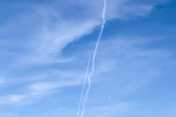 istock Aircraft condensation contrails in the blue sky inbetween some clouds 1320702910