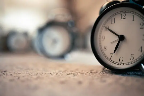 Close-up of a black retro alarm clock in the room