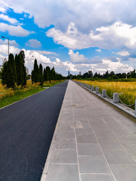 istock Long pavement and bike path next to road and Soviet Officers Cemetery 1320705492