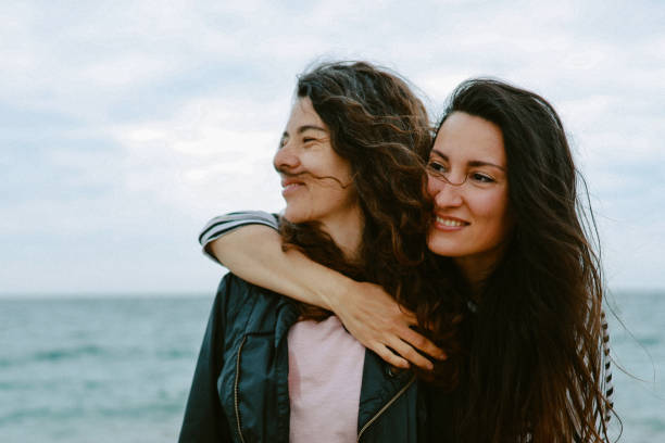 istock Female friends enjoy walking the beach 1320707483