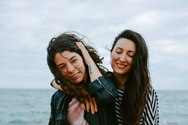 istock Female friends enjoy walking the beach 1320707588
