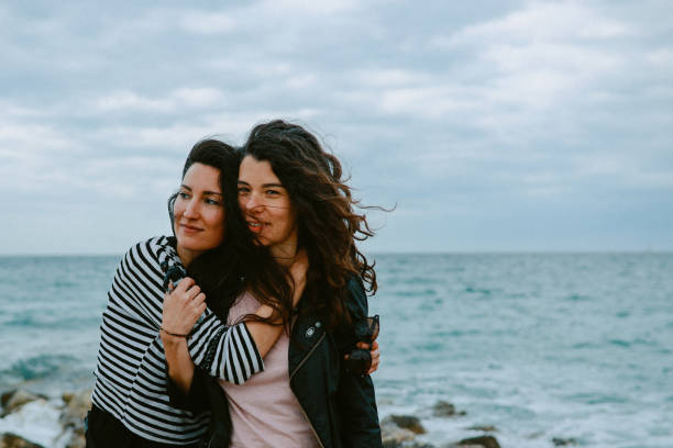 istock Female friends enjoy walking the beach 1320707601