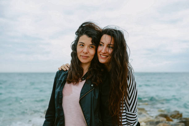 istock Female friends enjoy walking the beach 1320708126