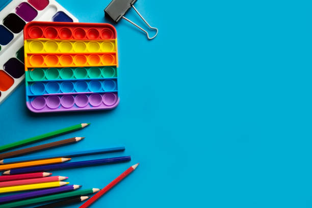 istock pop it toy, watercolors, colored pencils on a blue background with place for text. 1320708129