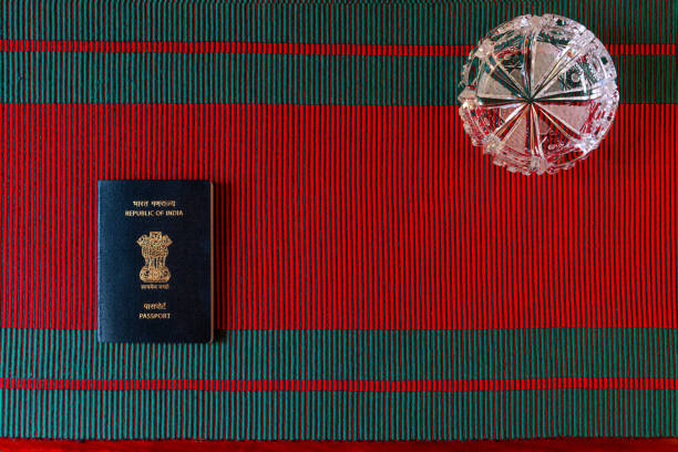 flat lay of the new india passport umieszczone na tkanej tkaniny czerwony i zielony podpowiedzi na boże narodzenie. górna połowa obrazu ma kryształową popielniczkę - passport blank book cover empty zdjęcia i obrazy z banku zdjęć