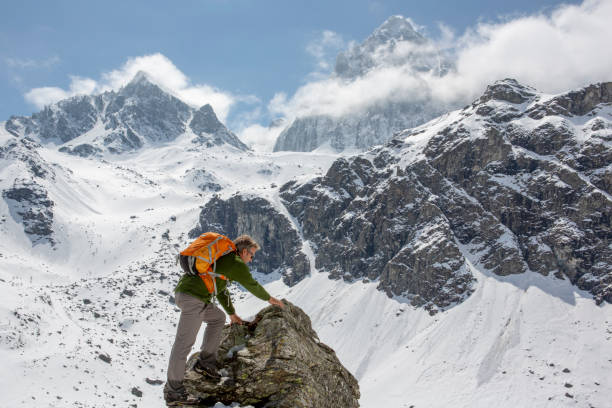istock Hiker scrambles to top of mountain 1320709837