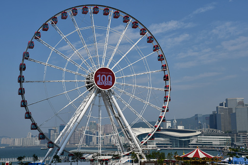 Hong Kong, China - August 9, 2019: The Hong Kong Observation Wheel in Central, with Victoria Harbour in the background.