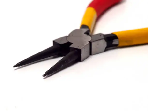Picture of snap ring plier that has a yellow - red handle. Shoot on white isolated background.
