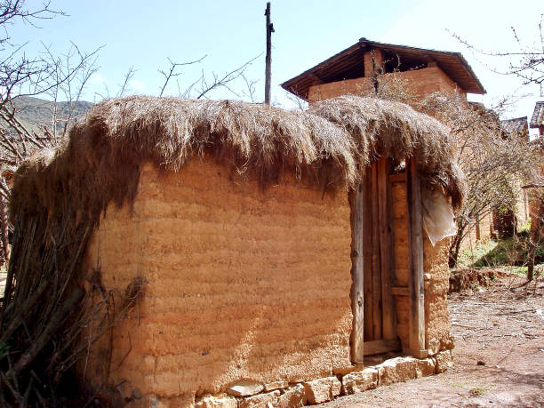 Mao Fang "Grass House" Village Toilet Yuxi, Yunnan China- January 11, 2019:  A traditional village toilet called "Mao Fang", named after the grass roof. It is rudimetary and generally consists of wooden boards with a narrow slit layed over an open pit cesspool. yunnan province stock pictures, royalty-free photos & images