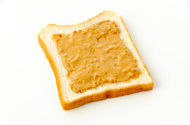 istock peanut butter on a slice of white bread. 1320723797