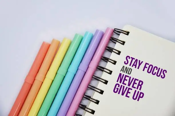 Photo of 'Stay focus and never give up' quote on the notebook.