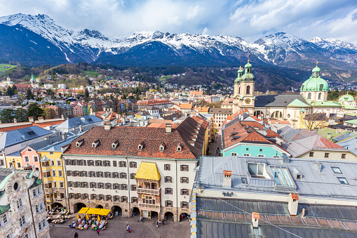 Innsbruck, Austria - 11 APRIL 2015 - Aerial view of Innsbruck old town shows the famous Goldenes Dachi and beatiful snow mountain ranges in the background